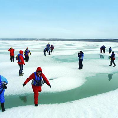 Reizigers wandelen over een gletsjerlandschap tijdens de groepsrondreis Spitsbergen, Groenland en IJsland.