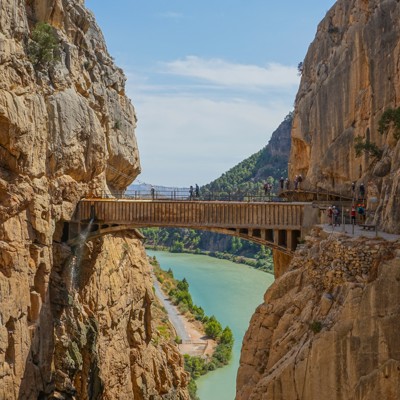 Wandelaars op de Caminito del Rey langs een kloof met rivier in Andalusië, Spanje.