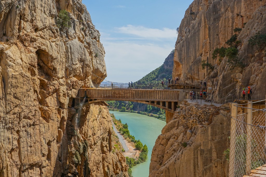 Wandelaars op de Caminito del Rey langs een kloof met rivier in Andalusië, Spanje.