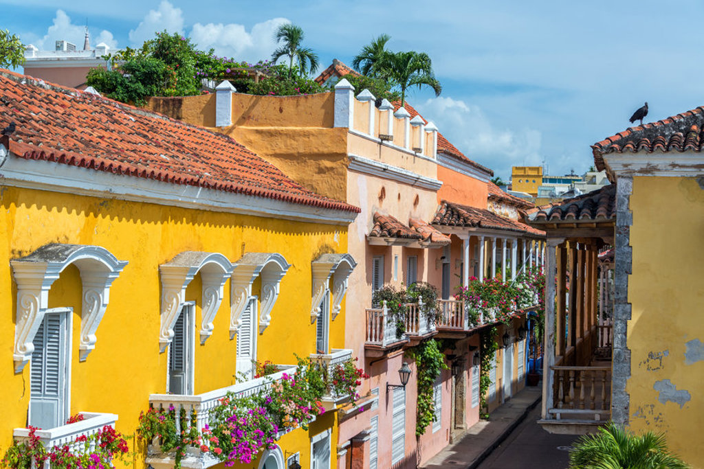 Kleurrijke straat met balkons vol bloemen en rode dakpannen in Cartagena, Colombia, tijdens een 22-35ers reis.