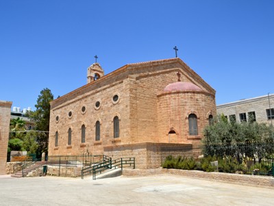 Stenen kerk met koepel en kruisen in Madaba, Jordanië.