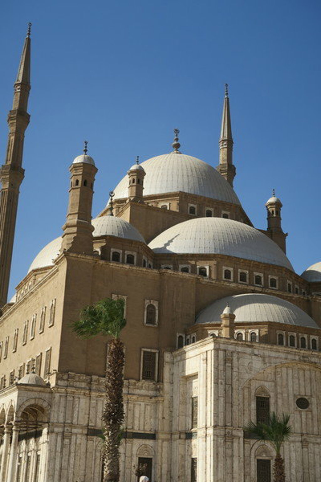 Moskee van Mohammed Ali in Caïro met koepels en minaretten onder een heldere blauwe lucht.