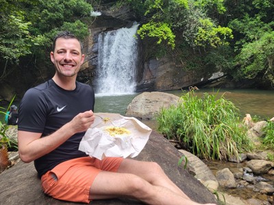 Reiziger picknickt bij een waterval in de jungle van Sri Lanka.