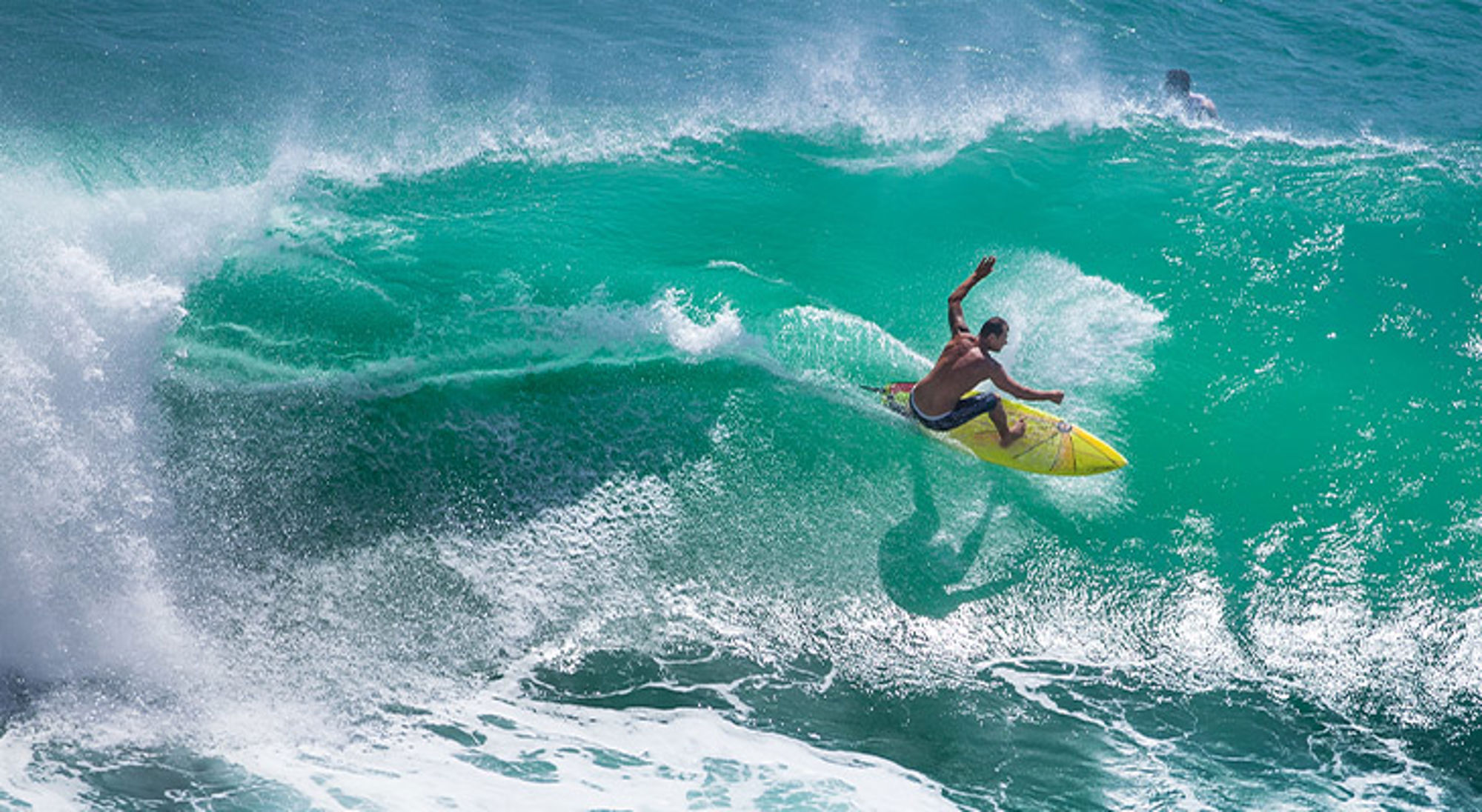 Padang Padang Beach Bali Surfer maakt een scherpe bocht op een hoge turquoise golf.