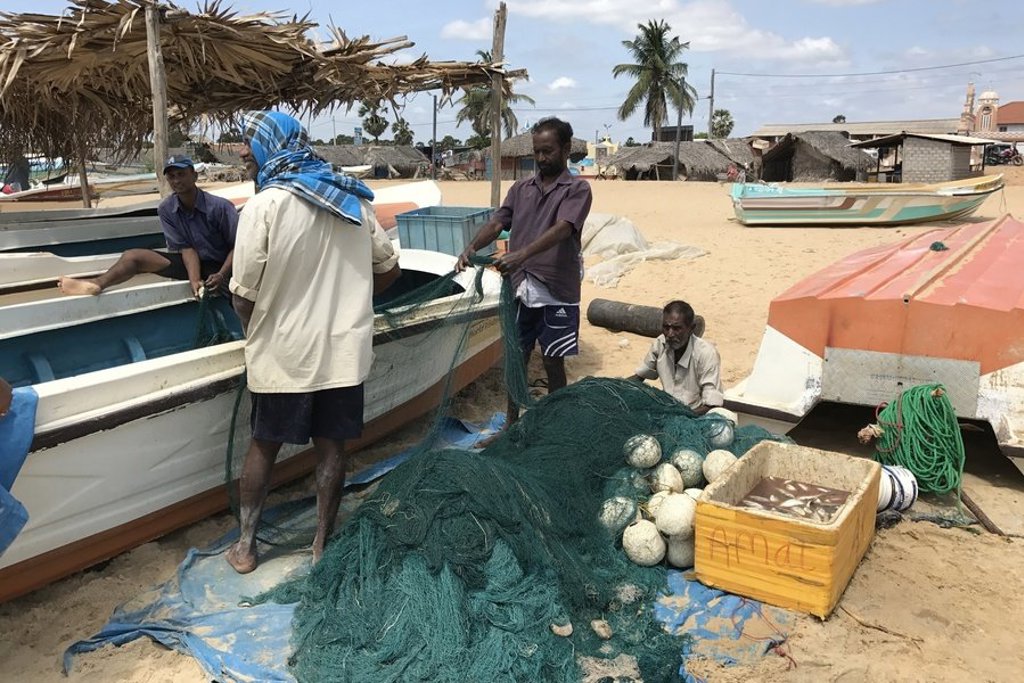 Vissers repareren netten op het strand in Sri Lanka tijdens een groepsrondreis.