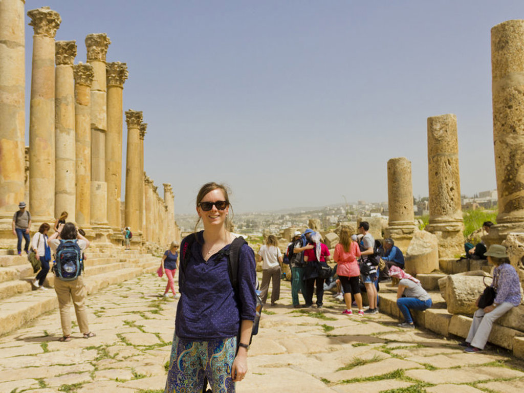 Reiziger bij de Romeinse zuilenstraat in Jerash, Jordanië, tijdens een groepsrondreis.