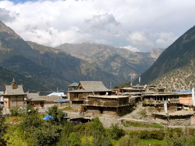 Traditioneel bergdorp in de Spiti-vallei met houten huizen, omringd door hoge Himalaya-bergen.