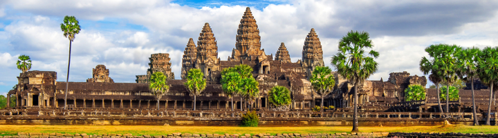 Angkor Wat tempelcomplex met palmbomen onder een bewolkte lucht.