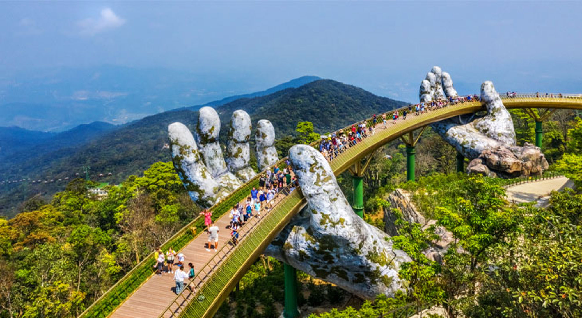 Gouden Brug Da Nang Gouden Brug (Golden Bridge) in Ba Na Hills, Da Nang, Vietnam, gedragen door reuzenhanden boven het berglandschap.