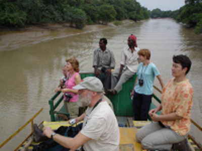 Reizigers op een kleine boot op een brede rivier in Orissa tijdens de Route Orissa, 23 dagen.
