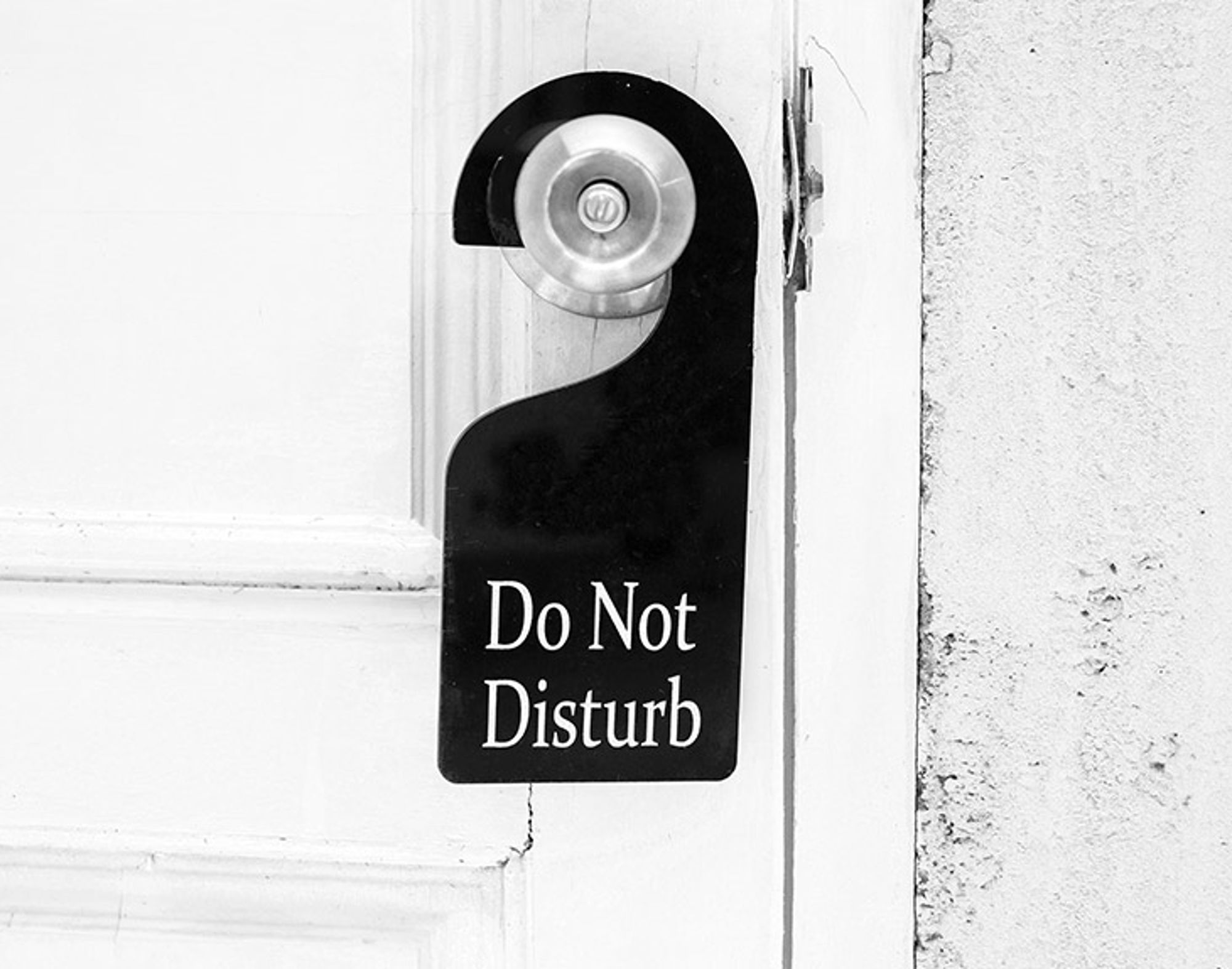 Niet storen bordje, jetlag Do Not Disturb-deurhanger aan een hotelkamerdeur.