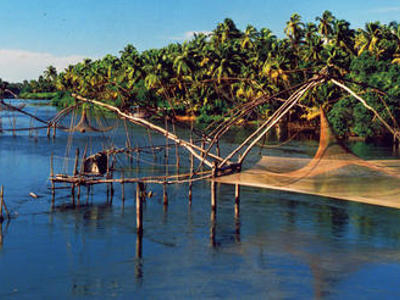 Chinese visnetten aan de waterkant in Kochi, Zuid-India, met palmbomen op de achtergrond.