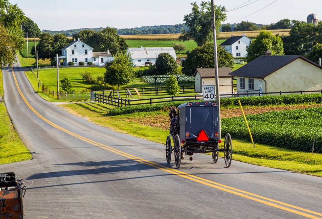 Amish-koets op een landweg langs boerderijen in het noordoosten van de Verenigde Staten.