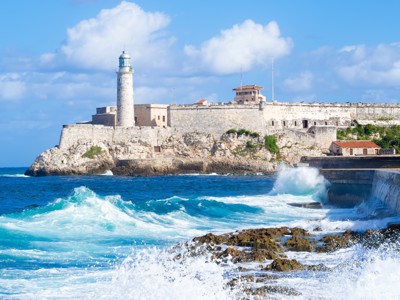 Fort El Morro met vuurtoren aan de kust van Havana, Cuba, met golven die tegen de rotsen slaan.