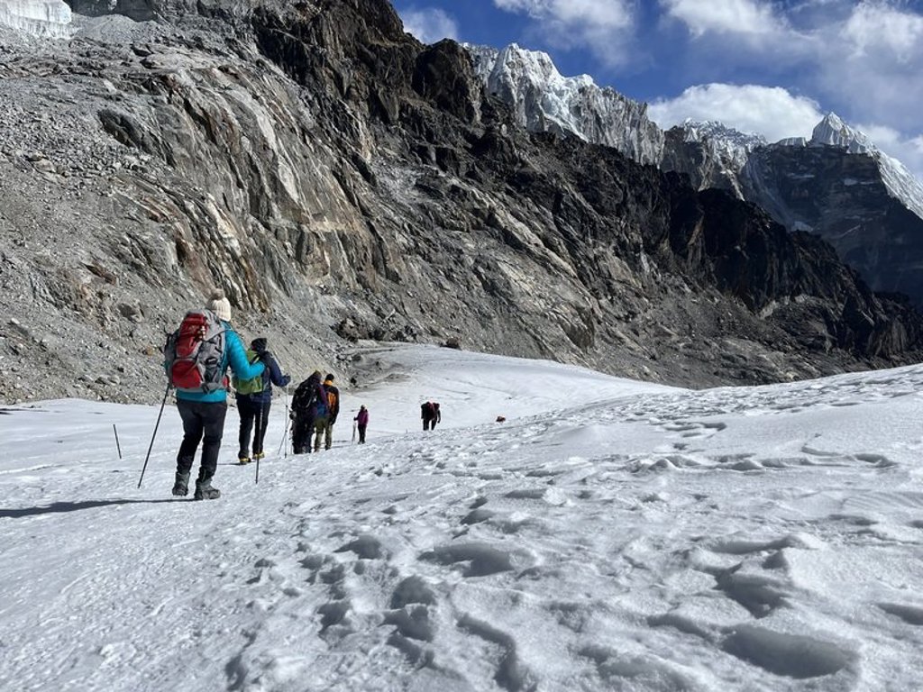 Trekker met rugzak op een bergpad in Nepal tijdens de Everest-trektocht.