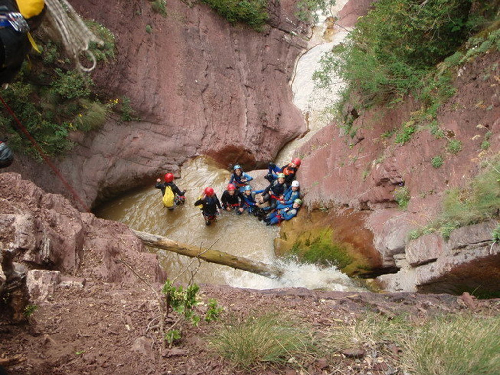 Groep met helmen tijdens canyoning in een rotsachtige kloof in Mercantour-Vésubie, Frankrijk.