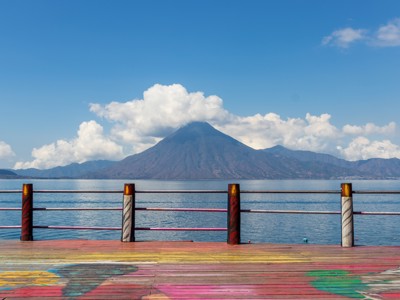 Uitzicht op het Atitlánmeer met de vulkaan San Pedro vanaf een kleurrijke pier in Guatemala.