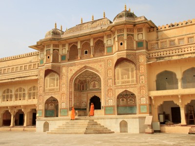 Fraai versierde toegangspoort van een paleis in Rajasthan, met twee bezoekers op de trappen.