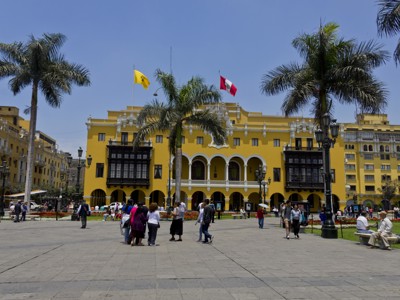 Plein Plaza Mayor in Lima met het gele regeringspaleis, palmbomen en de Peruaanse vlag.