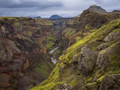 Diepe kloof met rivier en met mos begroeide rotswanden langs de Laugavegur Trail in IJsland.