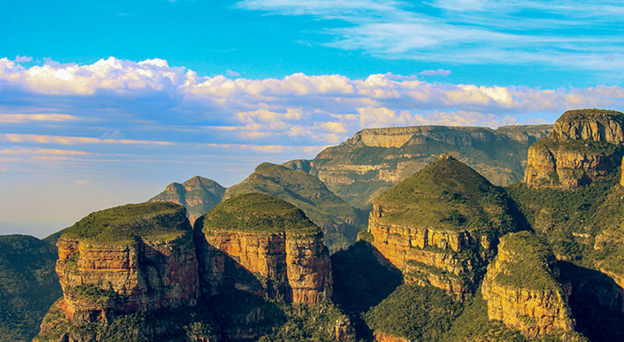 Uitzicht op de Blyde River Canyon met groene rotsformaties onder een blauwe lucht, Zuid-Afrika.