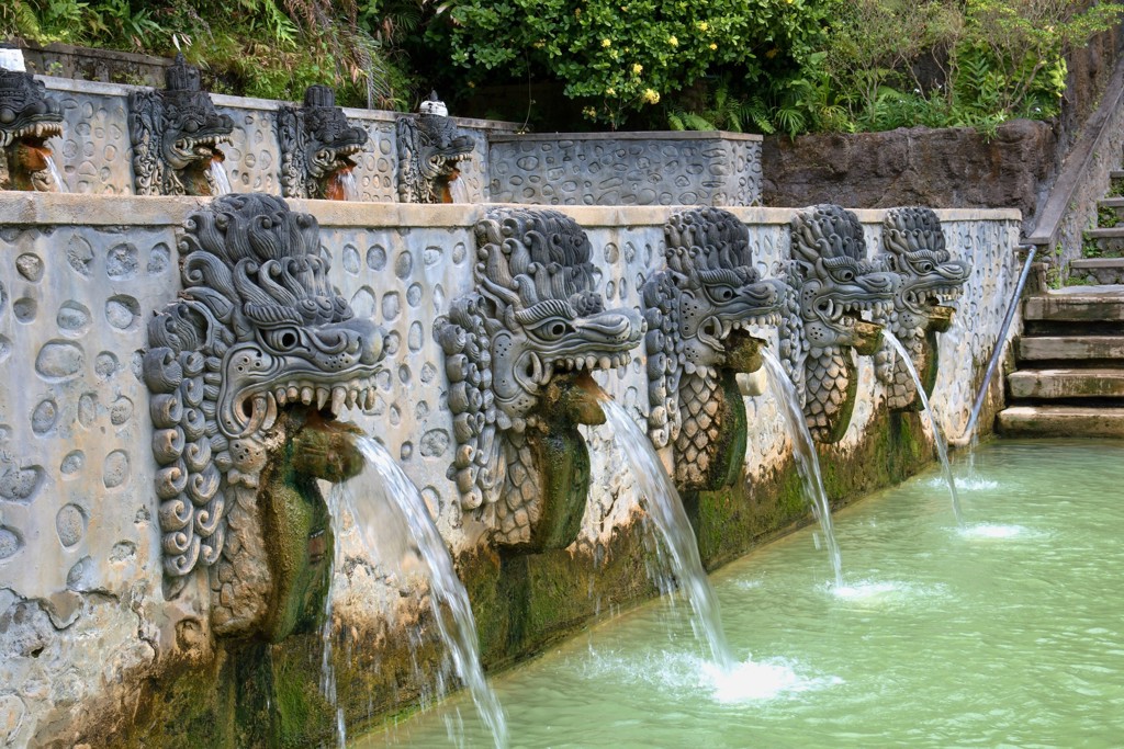 Waterspuwende drakenbeelden bij een tempelbad op Bali tijdens een groepsrondreis.