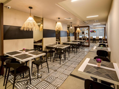 Ontbijtruimte van Arawi Express Miraflores met moderne tafels, stoelen en hanglampen.