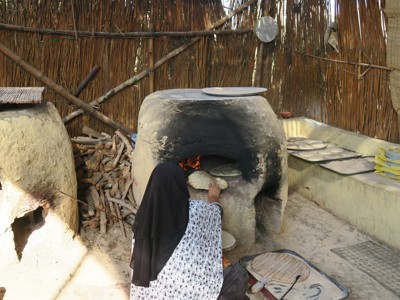 Vrouw bakt brood in een traditionele kleioven tijdens de Route Egypte, dag 5.