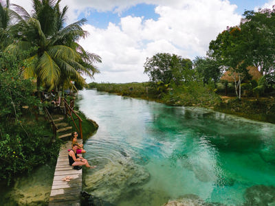 Houten steiger aan een turquoise lagune met palmbomen, route Mexico.