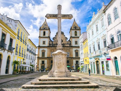 Pelourinho-plein in Salvador met stenen kruis en barokke kerk, Route Brazilië.