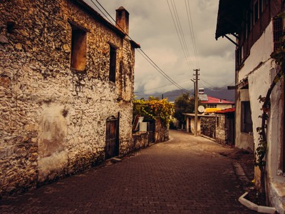Rustige dorpsstraat met oude stenen huizen langs de Turquoise Kust in Turkije.