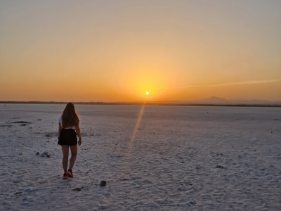 Wandelaar bij zonsondergang op de zoutvlakte van Larnaca, Route Cyprus.