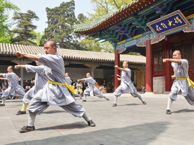 Shaolin-monniken demonstreren kungfu op de binnenplaats van een tempel in China.