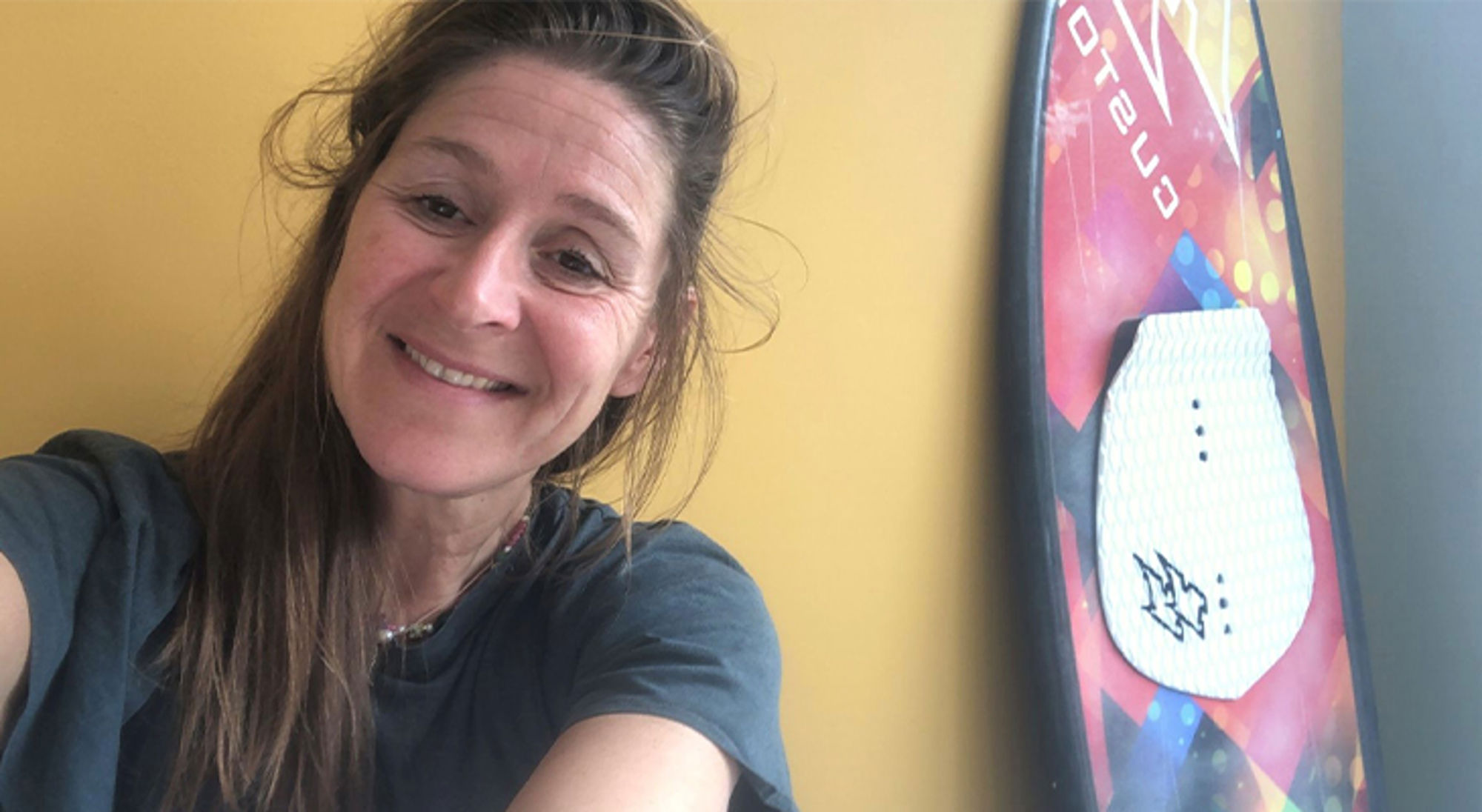 Tessa Vrouw maakt een selfie naast een snowboard met kleurrijke print.