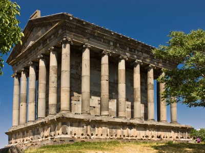 Tempel van Garni bij Jerevan, Armenië, met zuilen tussen groene bomen onder een blauwe lucht.
