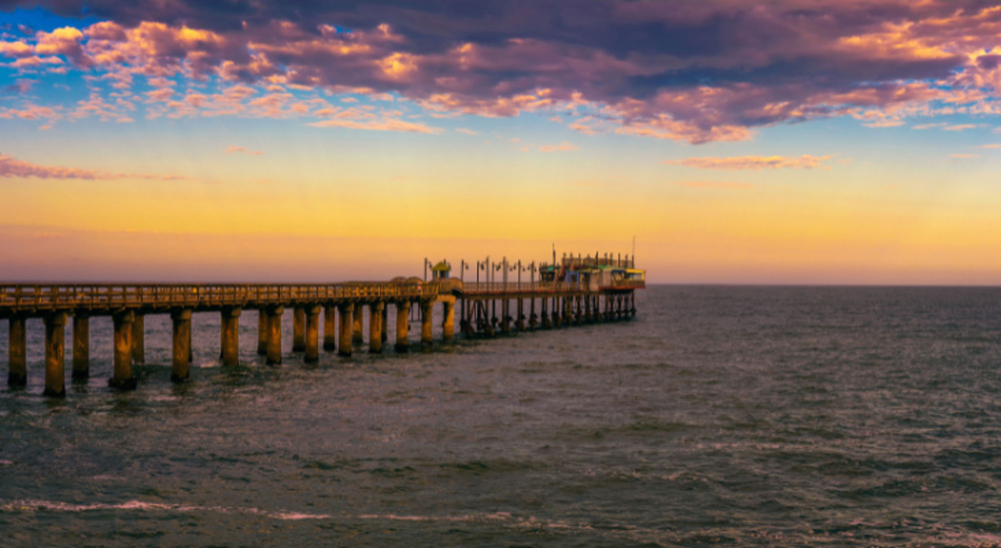 Kleurrijke zonsondergang over de oude historische pier in Swakopmund, Namibië. Steiger van Swakopmund bij zonsondergang aan de Atlantische kust van Namibië.