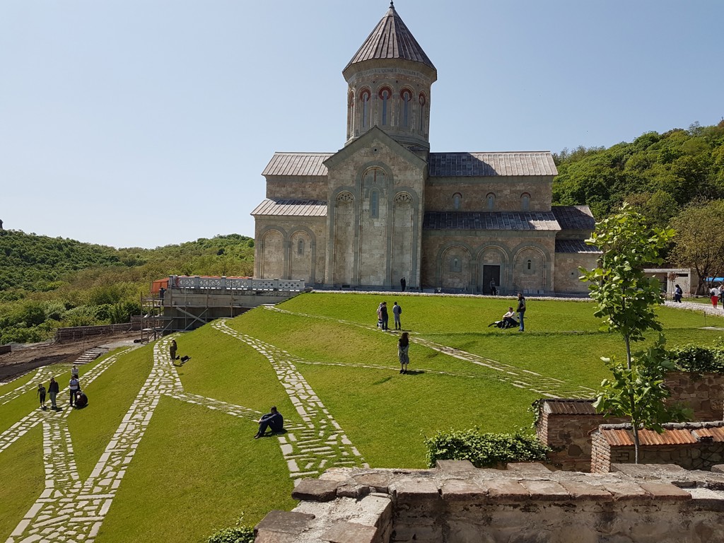 Svetitskhoveli-kathedraal in Mtscheta, Georgië, met bezoekers op het groene terrein ervoor.