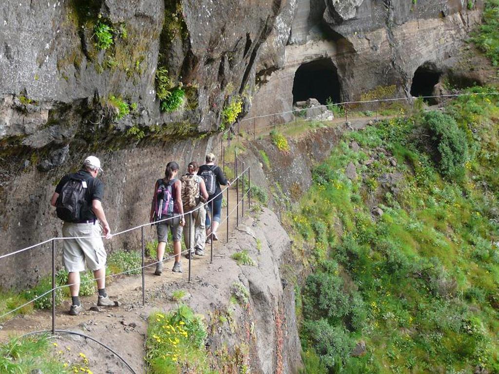 Wandelaar op een bergpad met uitzicht op de groene bergen van Madeira.