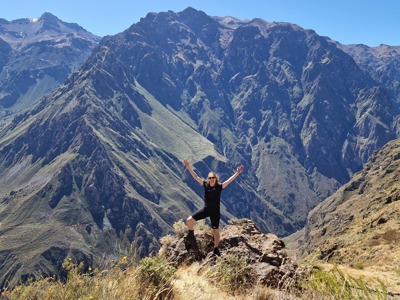 Wandelaar op een rots met uitzicht op de diepe Colca Canyon in Peru.