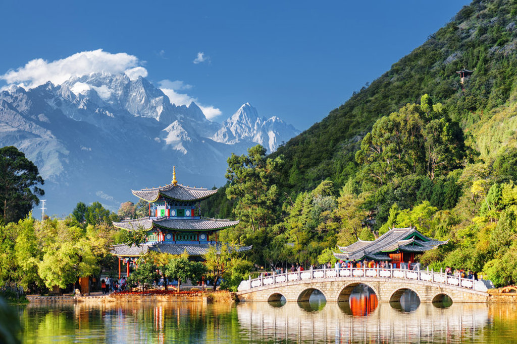 Pagode en stenen brug bij Black Dragon Pool in Lijiang, met besneeuwde Jade Dragon Snow Mountain op de achtergrond.