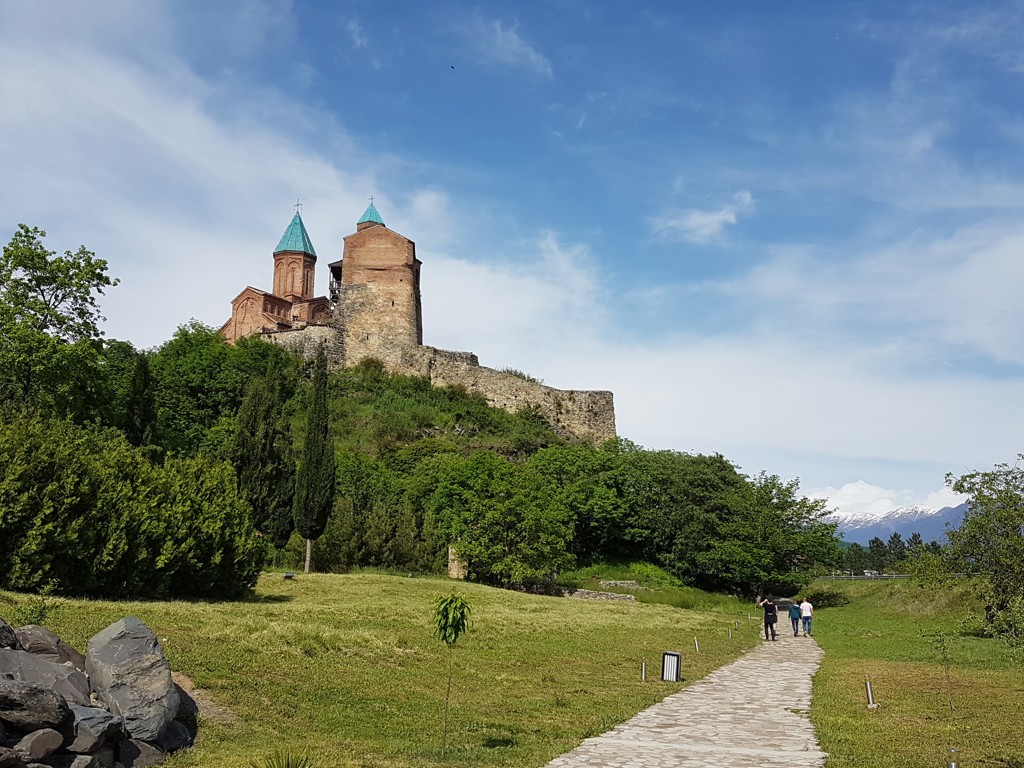 Kloostercomplex Jvari bij Mtskheta, Georgië, op een heuvel met wandelpad en uitzicht op de Kaukasus.