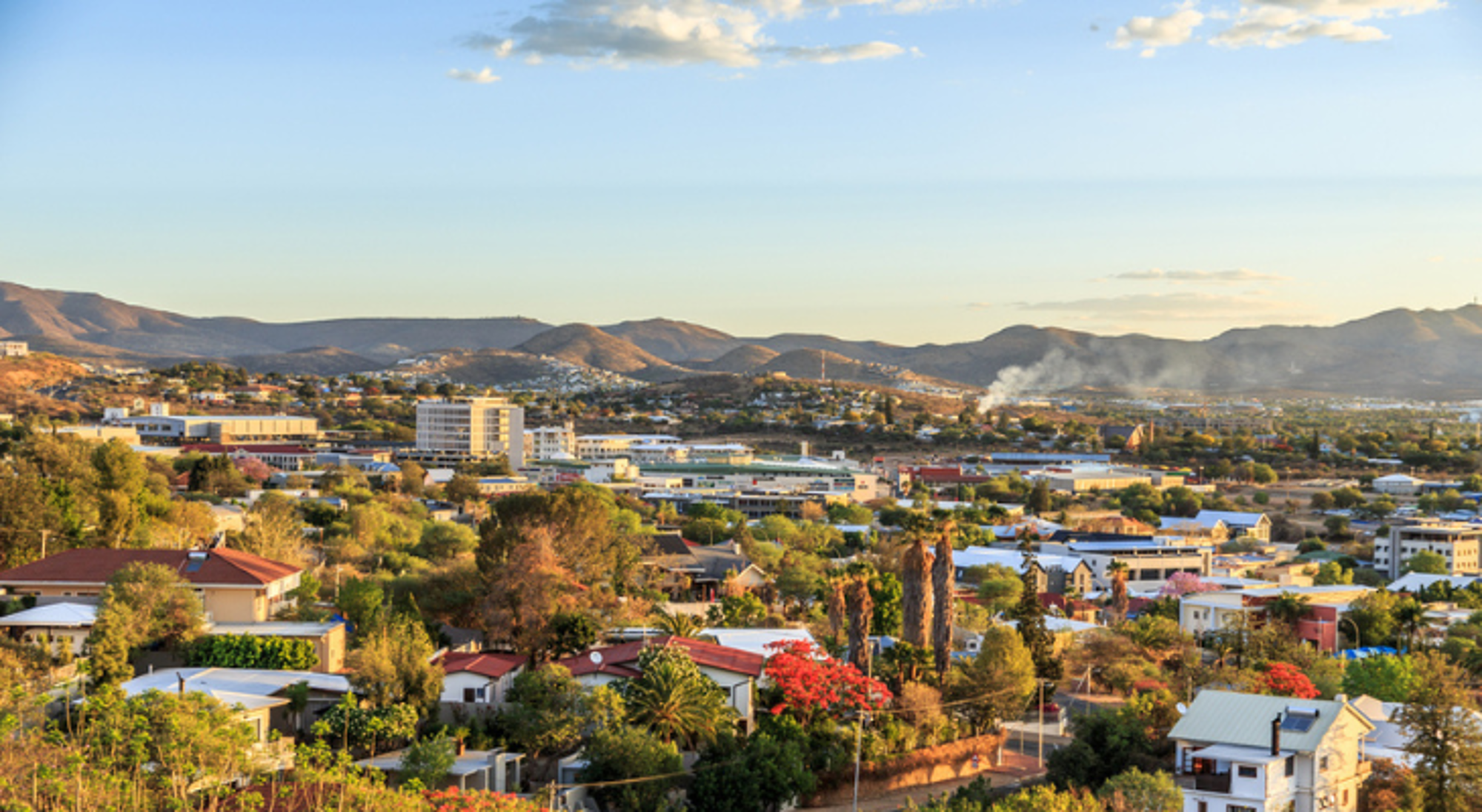 Uitzicht op het centrum van Windhoek met bergen op de achtergrond Panorama van Windhoek, Namibië, met stadscentrum en omliggende bergen bij zonsondergang.
