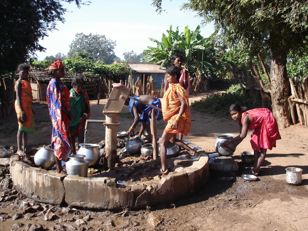 Dorpsbewoners halen water bij een handpomp in Orissa, India, tijdens een groepsrondreis.