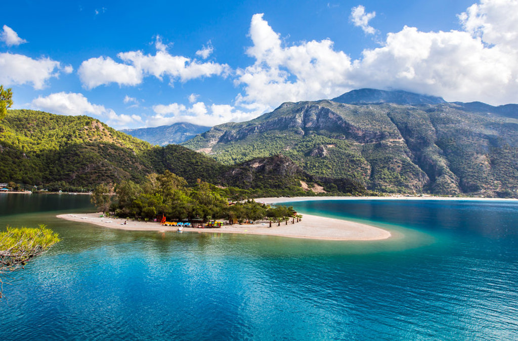 Turquoise baai met zandstrand en groene bergen aan de kust van Turkije tijdens een familiereis.