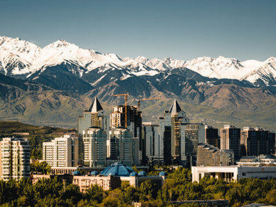 Skyline van Almaty met besneeuwde Tian Shan-bergen op de achtergrond tijdens de Zijderoute met de trein-reis.