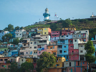 Kleurrijke huizen op een heuvel in Guayaquil, Ecuador, met de vuurtoren van Cerro Santa Ana bovenop.