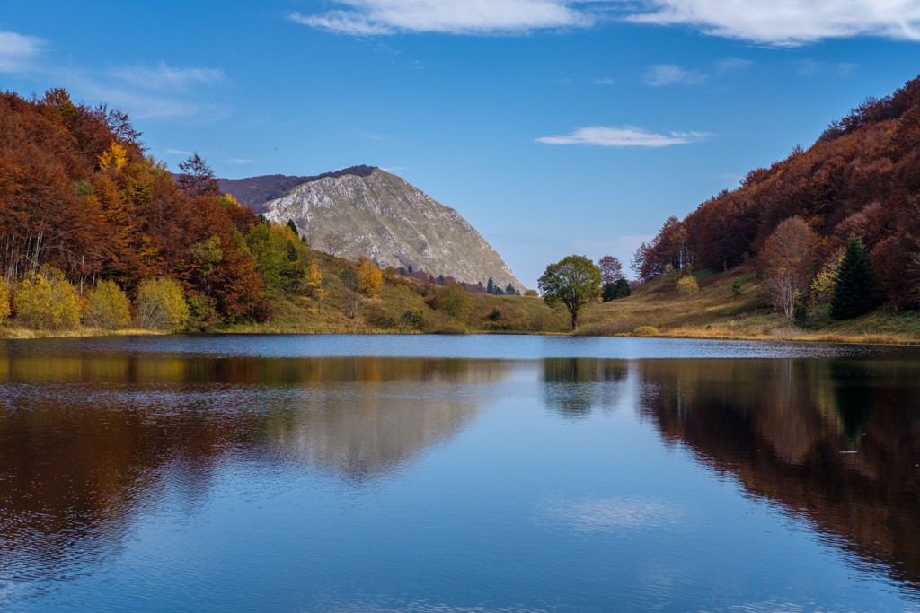 Bergmeer met herfstbossen en rotsachtige bergtop in Bosnië en Herzegovina.