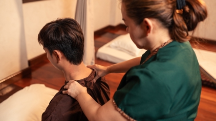 Thaise masseuse geeft een schoudermassage in een spa in Thailand.