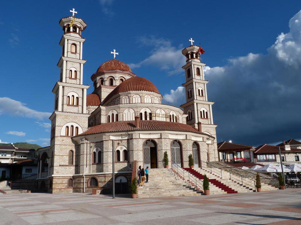Orthodoxe kerk met rode koepels en klokkentorens in Albanië, tijdens groepsrondreis Albanië, Kosovo & Noord-Macedonië.