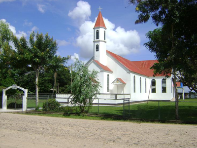 Witte kerk met rode daken en klokkentoren langs een weg, Route Nicaragua 23 dagen.